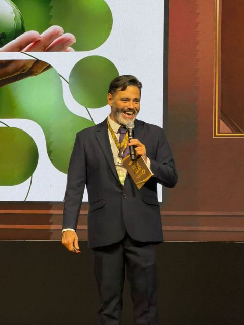 Professor Julio Araujo recebendo o prêmio Palestrante do Ano no palco