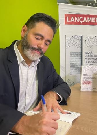 Julio Araujo assinando exemplar do livro no lançamento